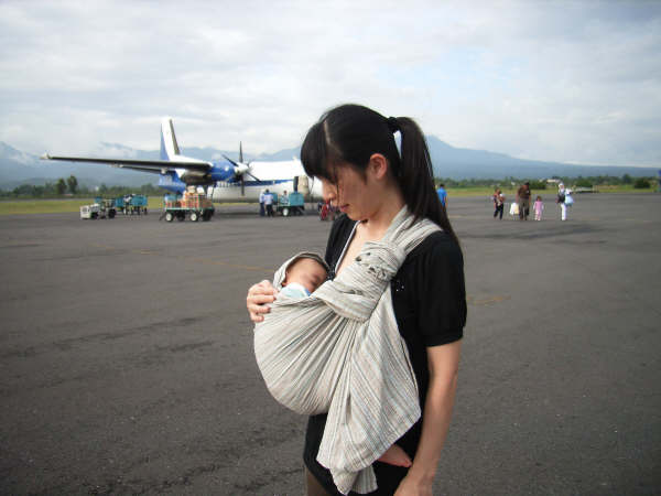 飛行機に乗る前にピースリングをつけて抱っこをしている写真