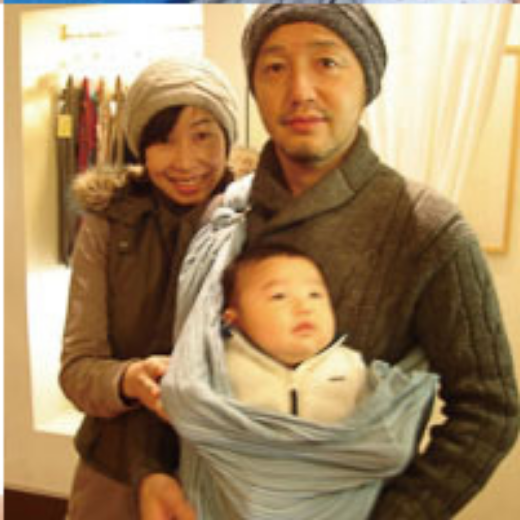 ペアルック風の帽子とスリングで赤ちゃんを抱いた家族