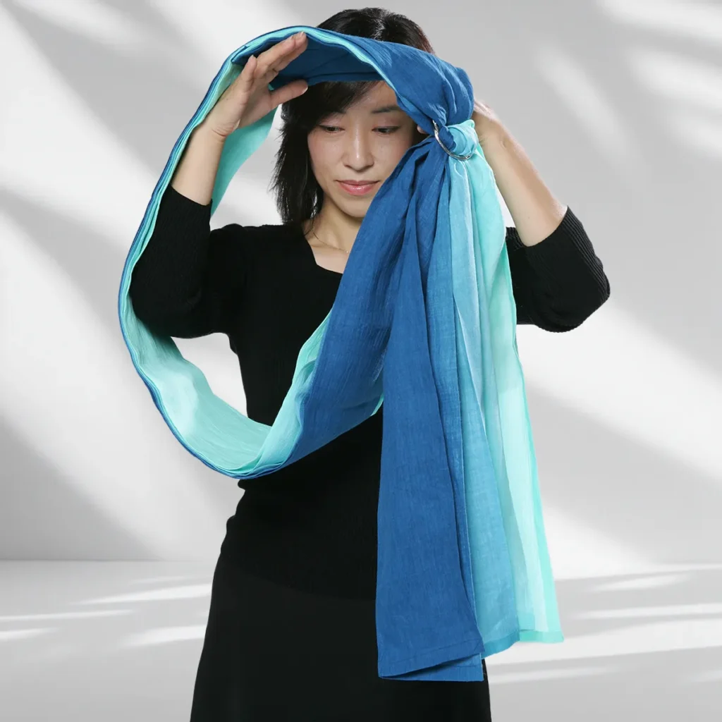 Pass the right arm and head through the loop, placing the sling on the left shoulder with rings below the collarbone