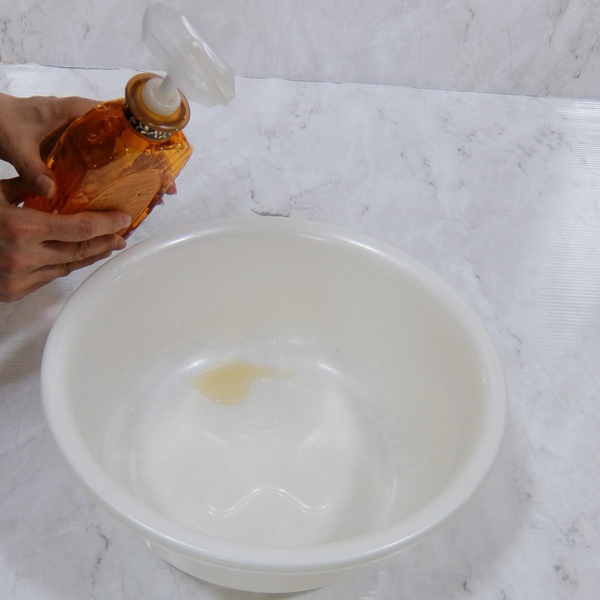洗面器にシャンプーを入れる